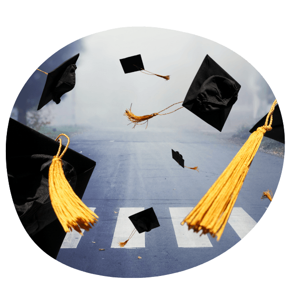 Graduation caps thrown in the air above a foggy crosswalk